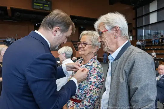 Wręczenie odznaczeń dwóm starszym osobom podczas uroczystości.