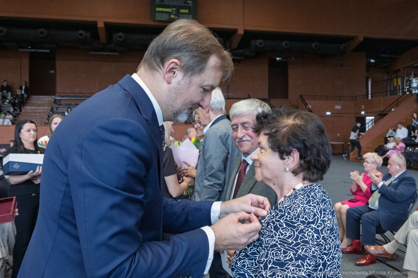 Uroczystość wręczenia odznaczeń, osoby w formalnych strojach, emocjonalne chwile.  Autor: Piotr Wojnarowski