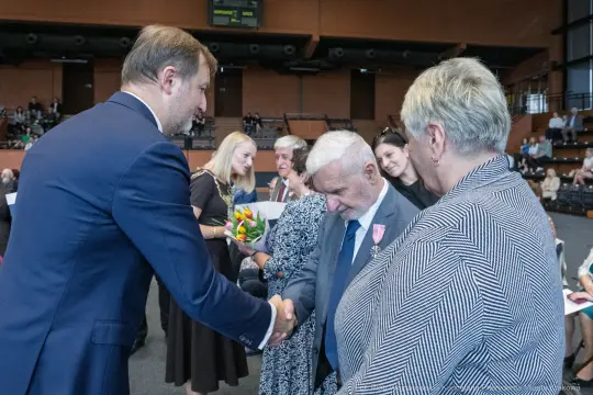 Uroczystość wręczenia odznaczeń, gratulacje i uściski dłoni.