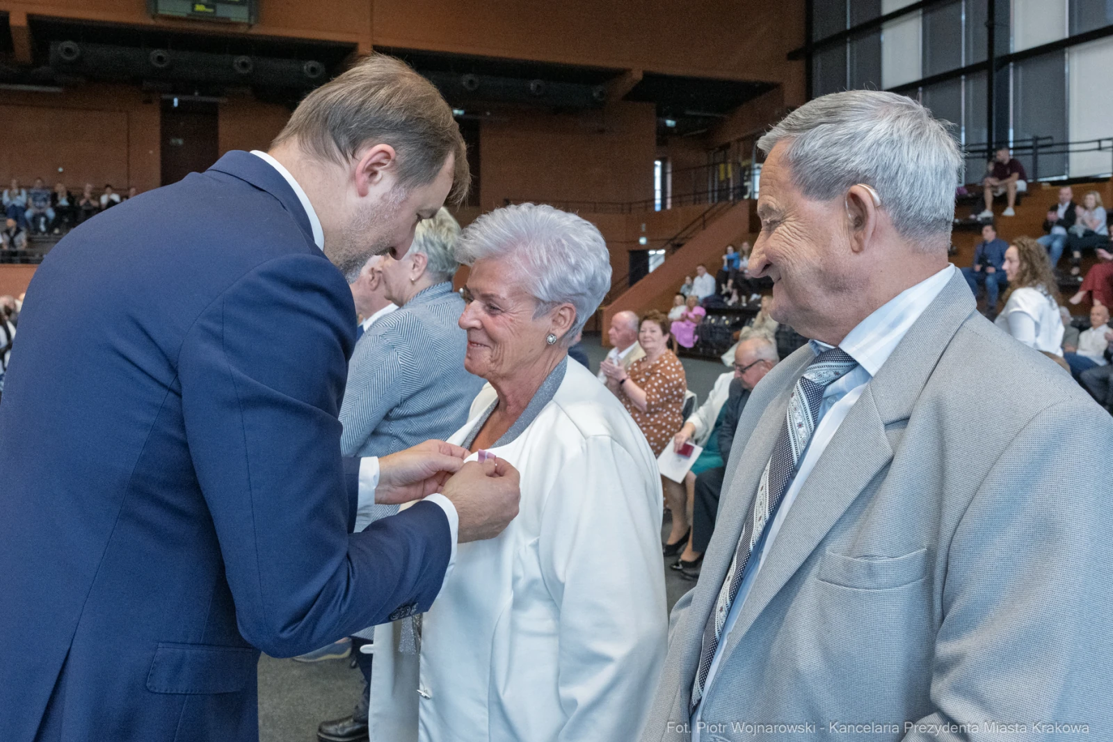 Uroczystość wręczenia odznaczeń, osoby w eleganckich strojach, emocjonalne chwile.  Autor: Piotr Wojnarowski