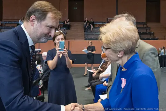 Uroczystość wręczenia odznaczeń, uściski dłoni i gratulacje.