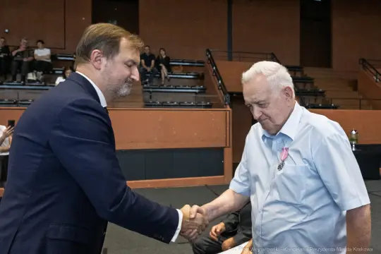 Mężczyźni uścisnęli sobie dłonie podczas ceremonii wręczenia odznaczeń.