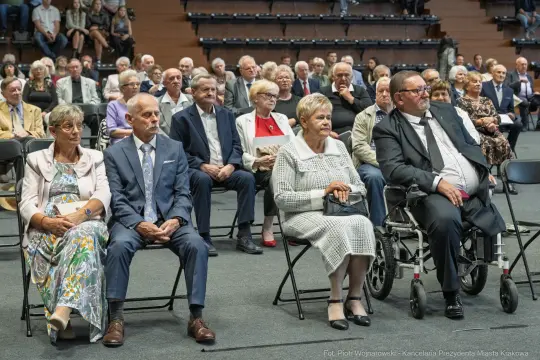 Grupa osób siedzących na widowni podczas wydarzenia.