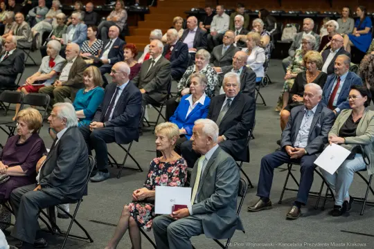 Grupa osób siedzących na widowni podczas wydarzenia.