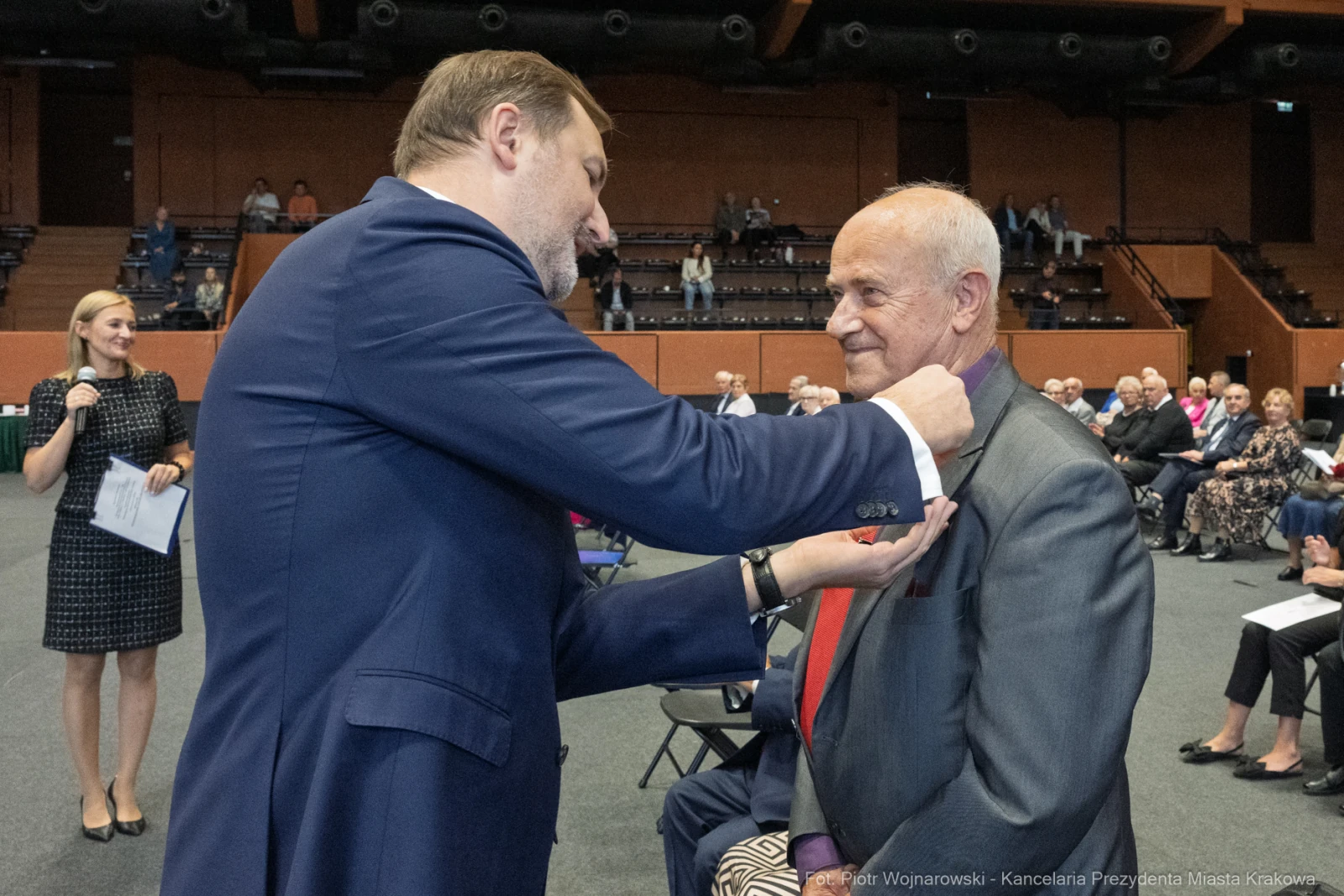 Wręczenie odznaczenia mężczyźnie w garniturze podczas uroczystości.  Autor: Piotr Wojnarowski