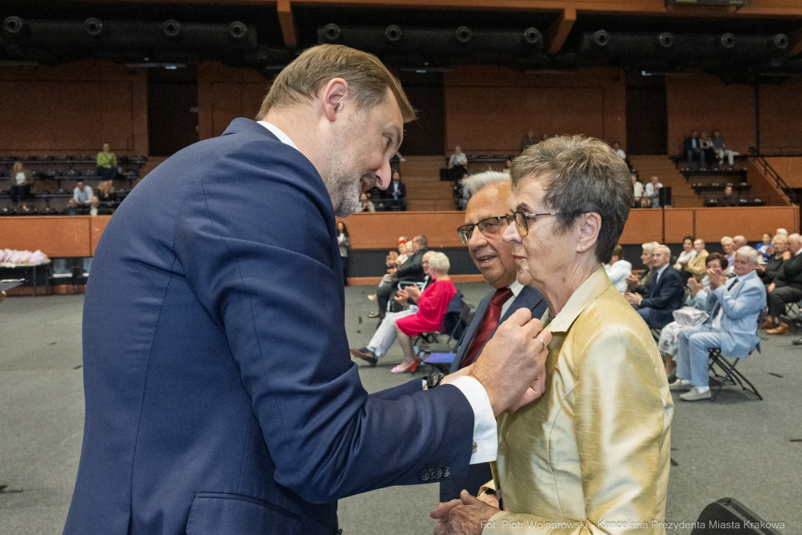 Spotkanie dwóch osób w eleganckich strojach, rozmowa w tle z innymi uczestnikami.  Autor: Piotr Wojnarowski