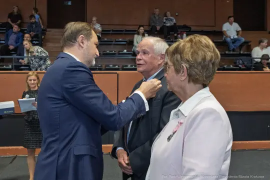 Wręczenie odznaczeń w sali konferencyjnej, rozmowy między uczestnikami.