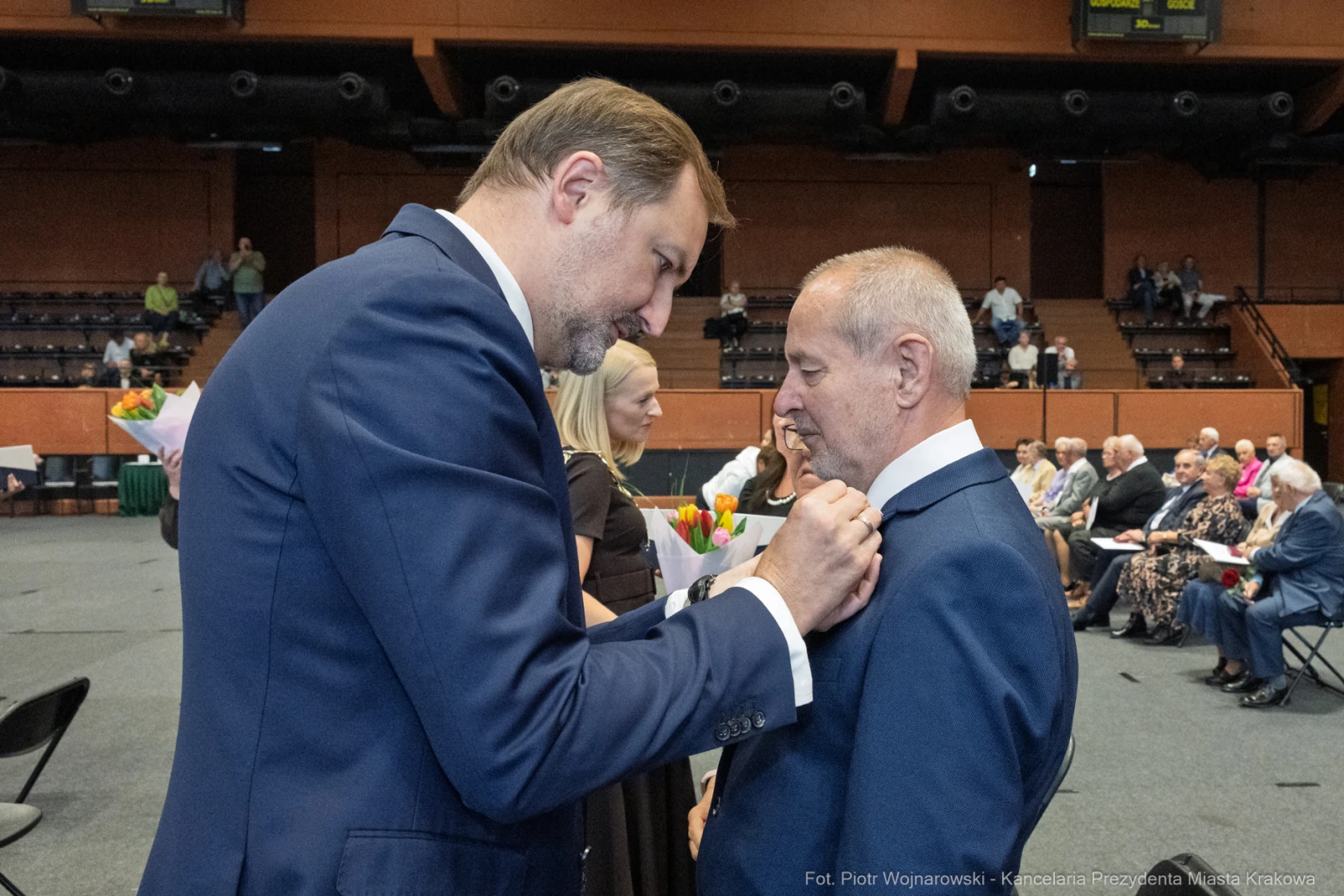 Wręczenie odznaczenia mężczyźnie w garniturze podczas uroczystości. W tle zgromadzeni goście.  Autor: Piotr Wojnarowski
