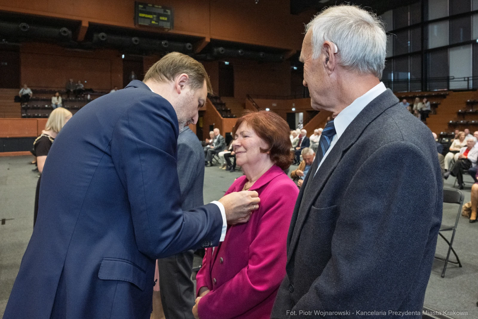 Uroczystość wręczenia odznaczeń, uśmiechnięte twarze, interakcja między osobami.  Autor: Piotr Wojnarowski