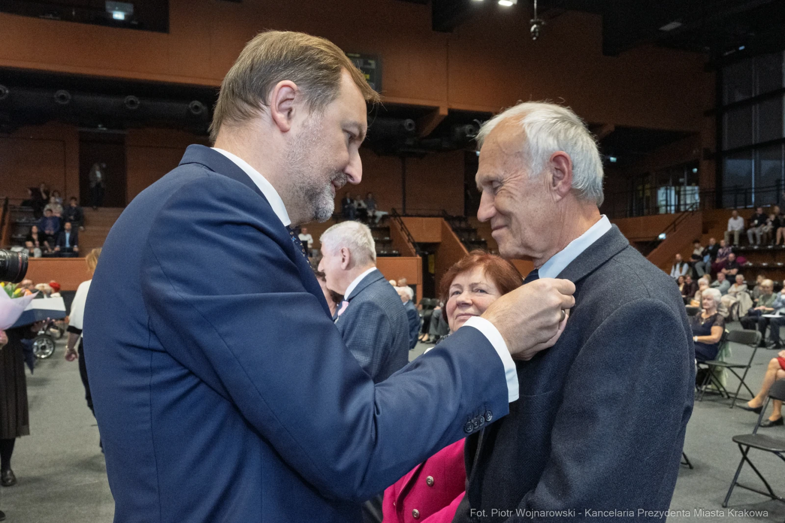Mężczyzna przypina odznaczenie innemu mężczyźnie podczas uroczystości.  Autor: Piotr Wojnarowski