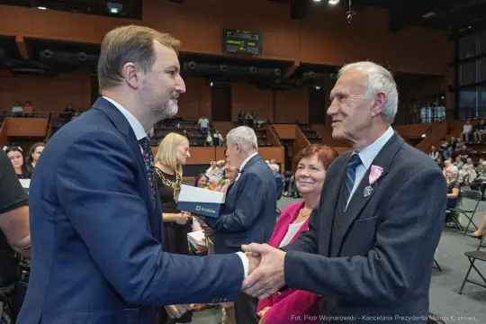 Uroczystość wręczenia nagród z uśmiechami i uściskami dłoni.