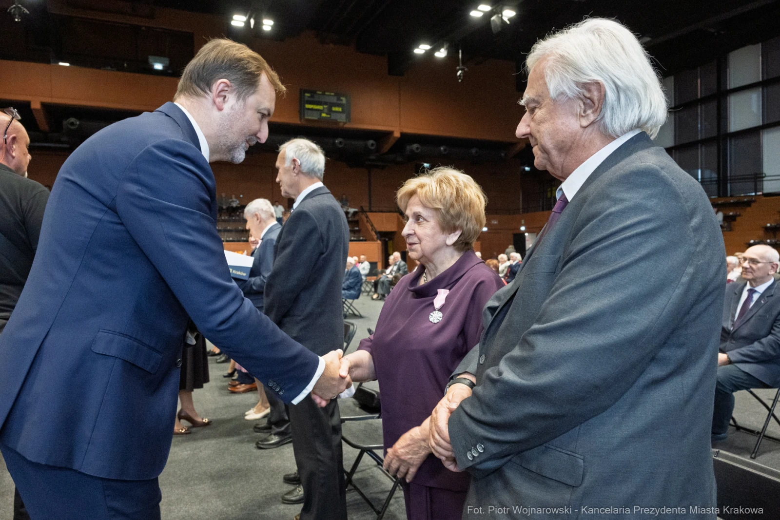 Uroczystość wręczenia odznaczeń, uściski dłoni i rozmowy między uczestnikami.  Autor: Piotr Wojnarowski