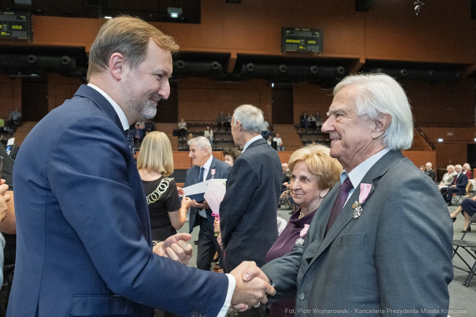 Uroczystość wręczenia odznaczeń, uściski dłoni i uśmiechy uczestników.  Autor: Piotr Wojnarowski