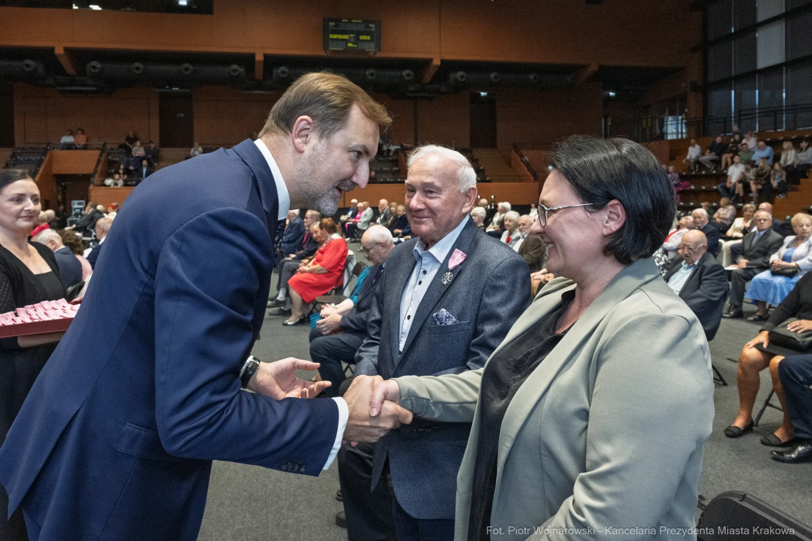 Wręczenie odznaczeń przez przedstawiciela władz lokalnych. Uczestnicy w formalnych strojach.  Autor: Piotr Wojnarowski
