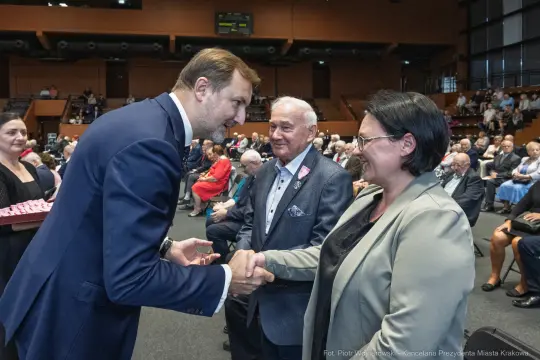 Wręczenie odznaczeń przez przedstawiciela władz lokalnych. Uczestnicy w formalnych strojach.