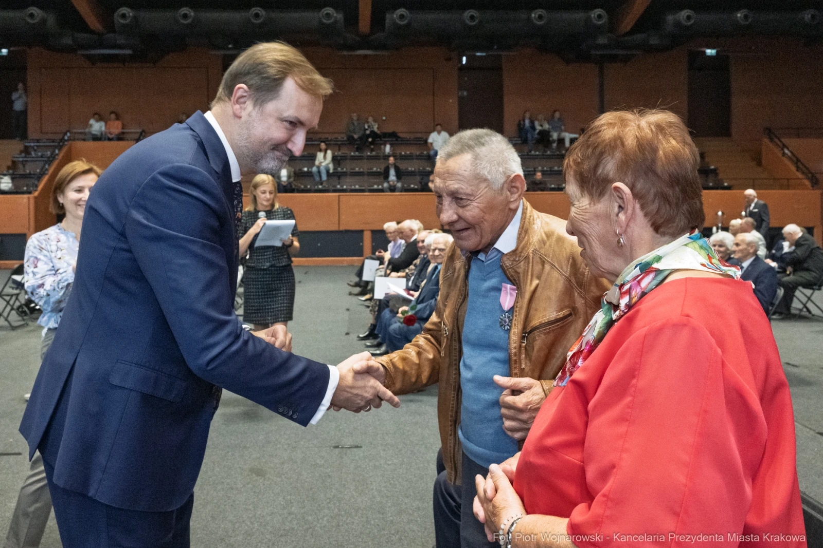Uroczystość wręczenia odznaczeń, uściski dłoni i rozmowy między uczestnikami.  Autor: Piotr Wojnarowski
