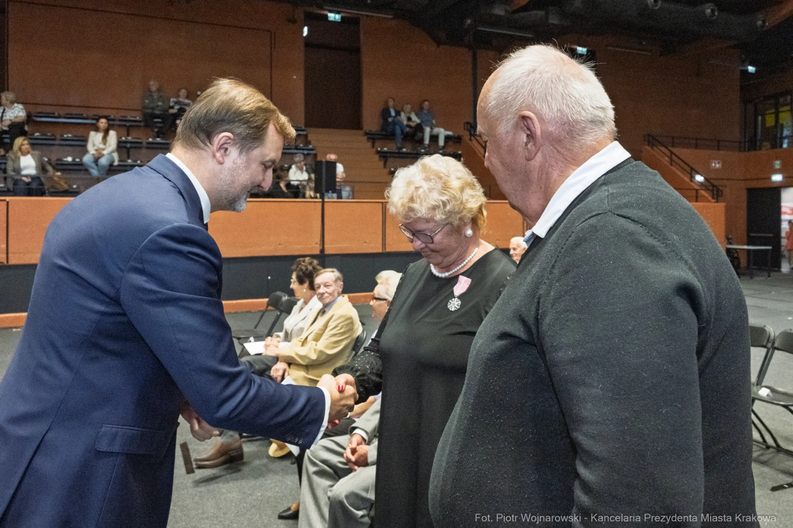 Spotkanie trzech osób, w tym mężczyzny w garniturze i starszej pary.  Autor: Piotr Wojnarowski