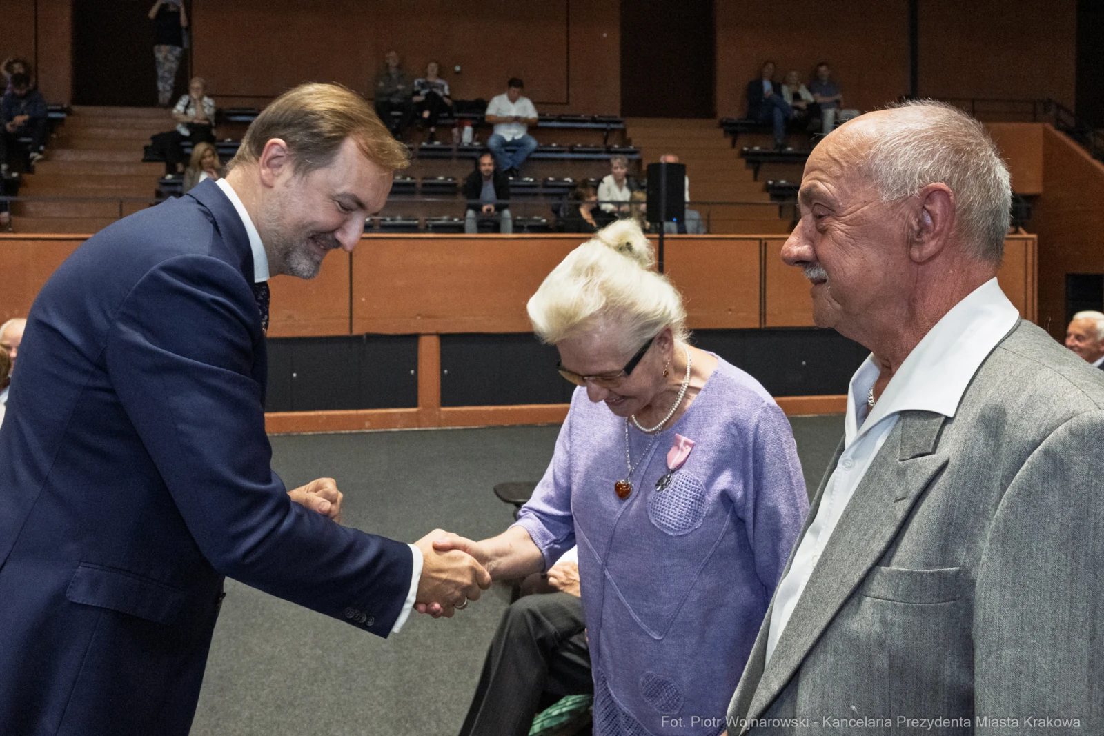 Spotkanie trzech osób, w tym mężczyzny w garniturze i starszej pary, podczas wydarzenia.  Autor: Piotr Wojnarowski