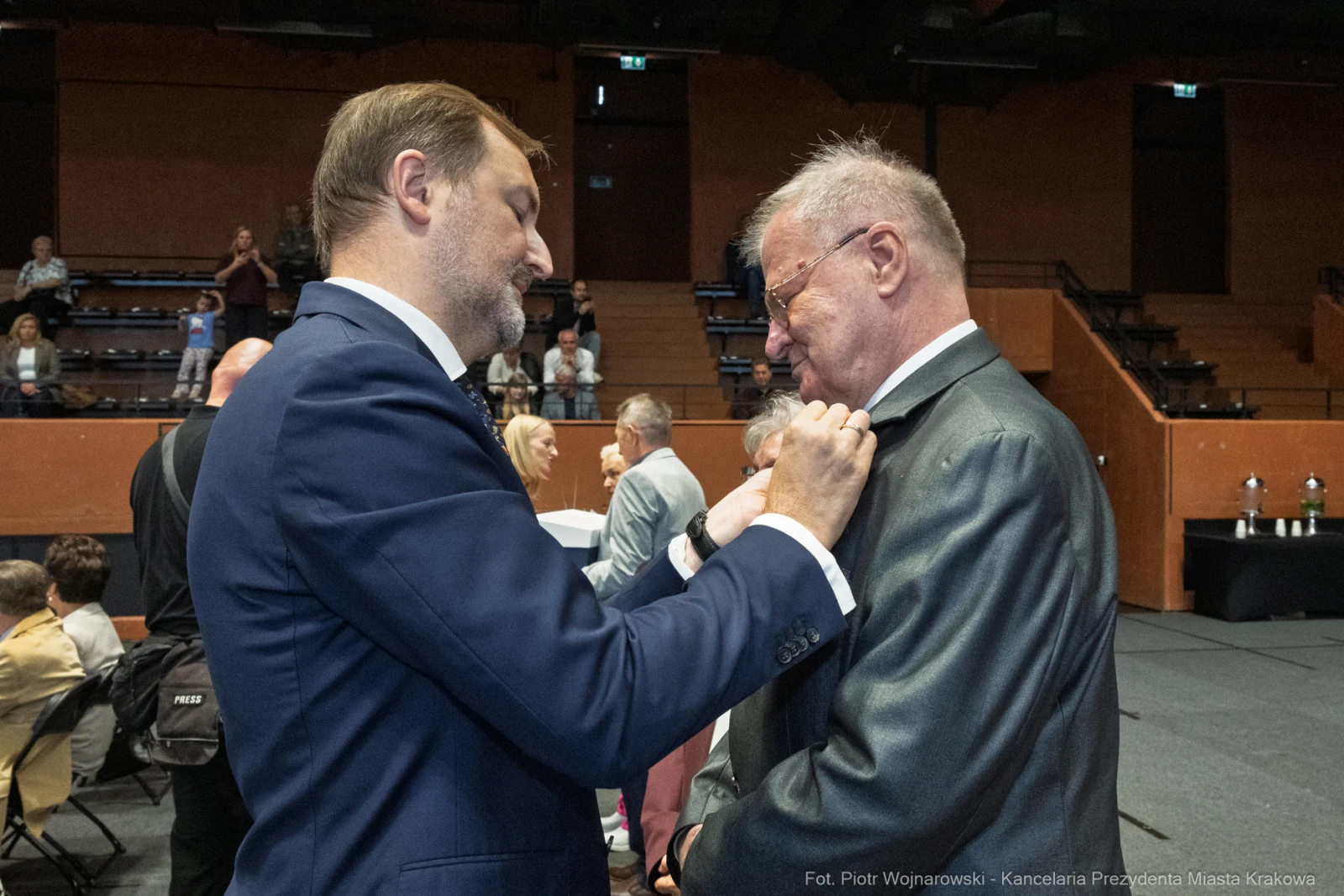Wręczenie odznaczenia mężczyźnie w garniturze podczas uroczystości.  Autor: Piotr Wojnarowski