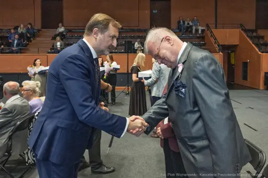 Mężczyźni uścisnęli sobie dłonie podczas ceremonii wręczenia nagród.