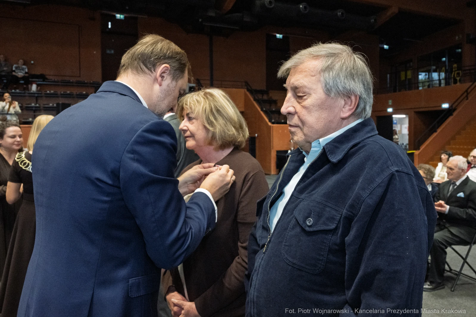 Wręczenie odznaczenia przez mężczyznę kobiecie, obok stoi mężczyzna.  Autor: Piotr Wojnarowski