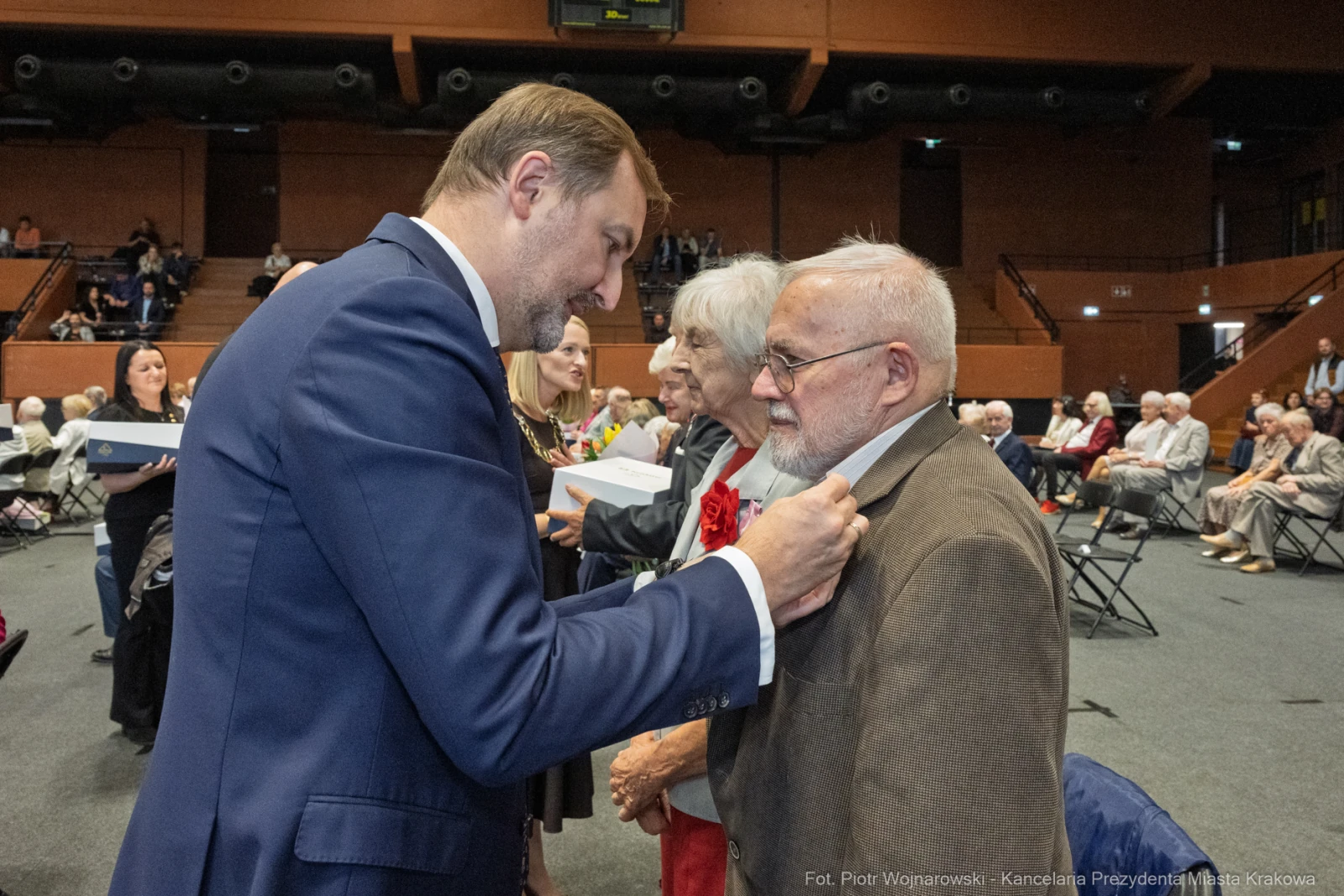 Wręczenie odznaczeń seniorom podczas uroczystości w sali konferencyjnej.  Autor: Piotr Wojnarowski