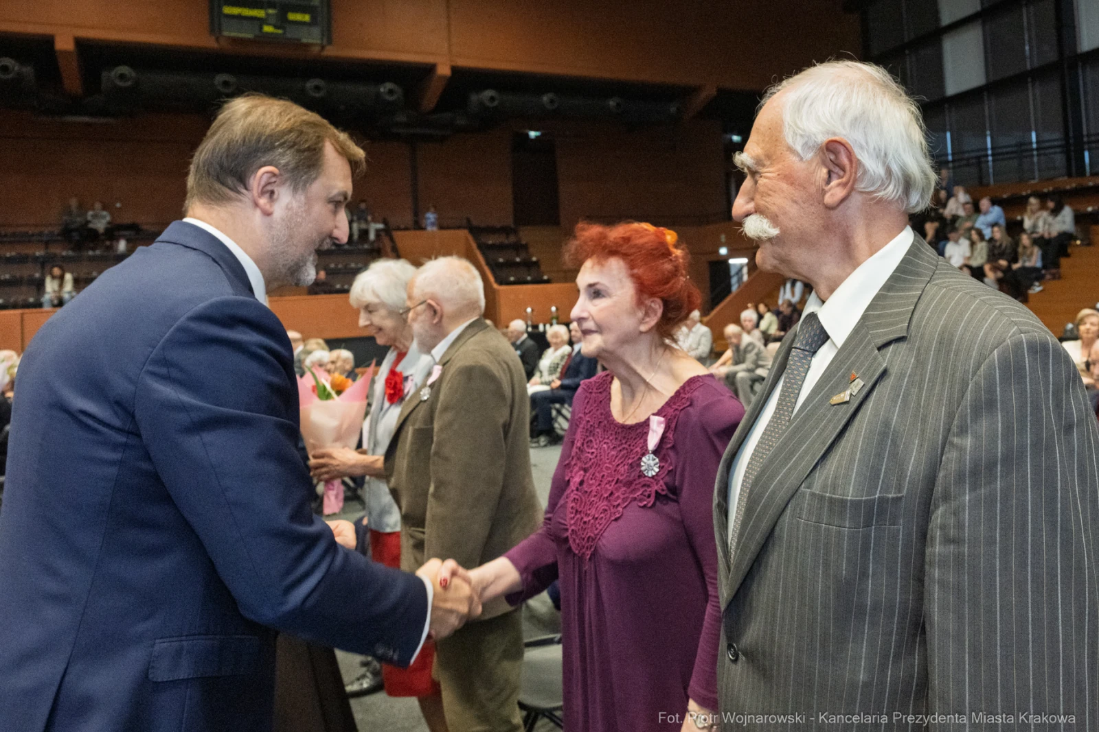 Uroczystość wręczenia odznaczeń, uściski dłoni i wzruszone twarze uczestników.  Autor: Piotr Wojnarowski