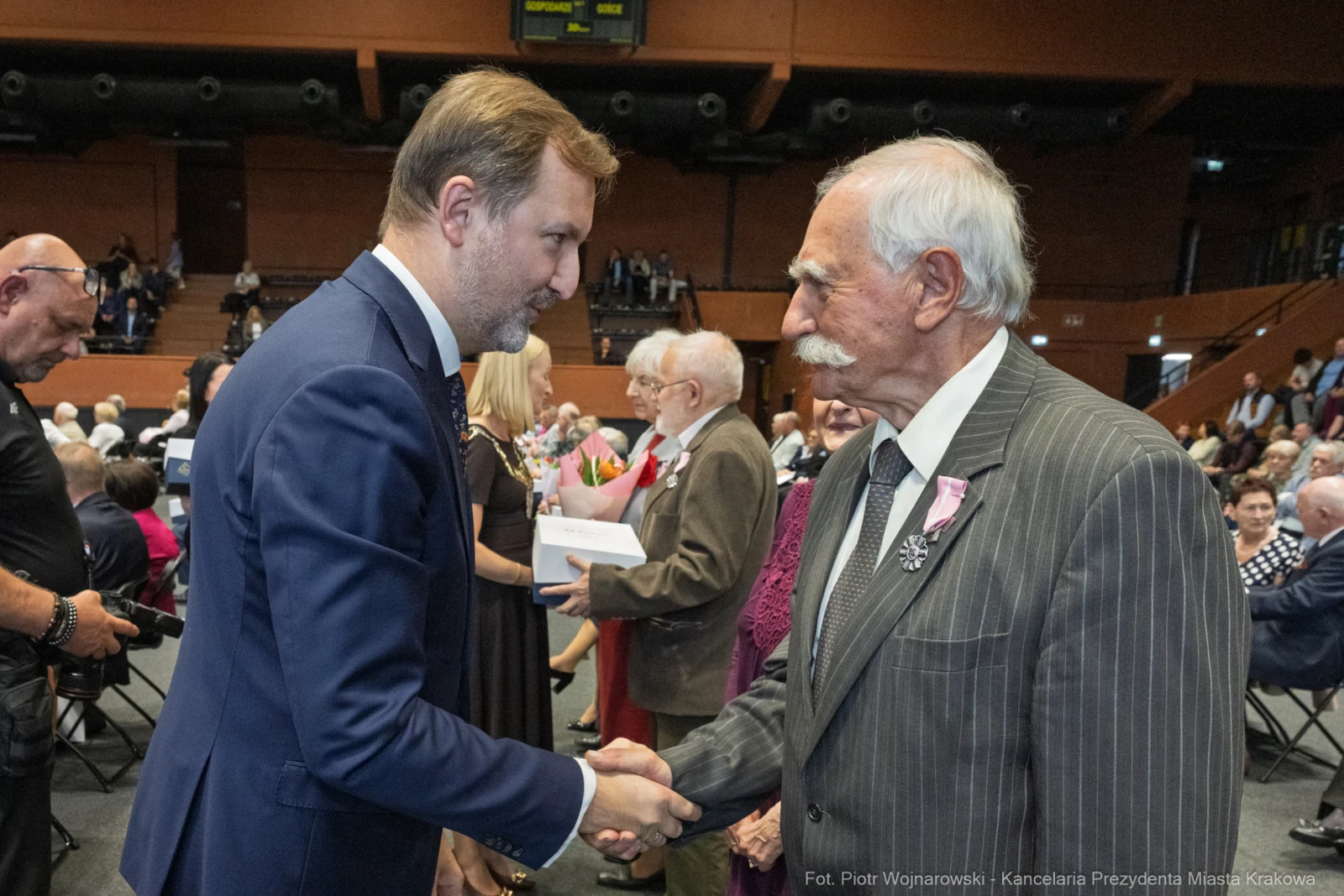 Uścisk dłoni dwóch mężczyzn podczas uroczystości wręczenia odznaczeń.  Autor: Piotr Wojnarowski