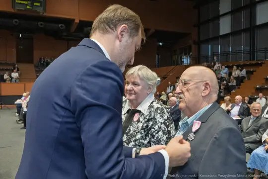 Wręczenie odznaczeń w trakcie uroczystości w sali konferencyjnej.