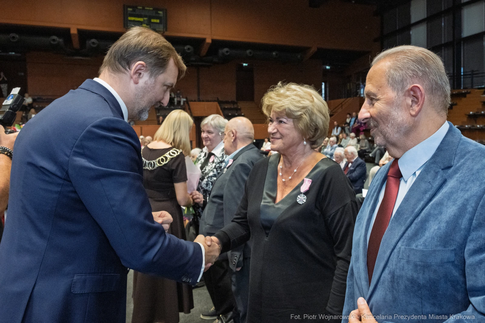 Spotkanie osób w formalnych strojach, uściski dłoni i rozmowy.  Autor: Piotr Wojnarowski