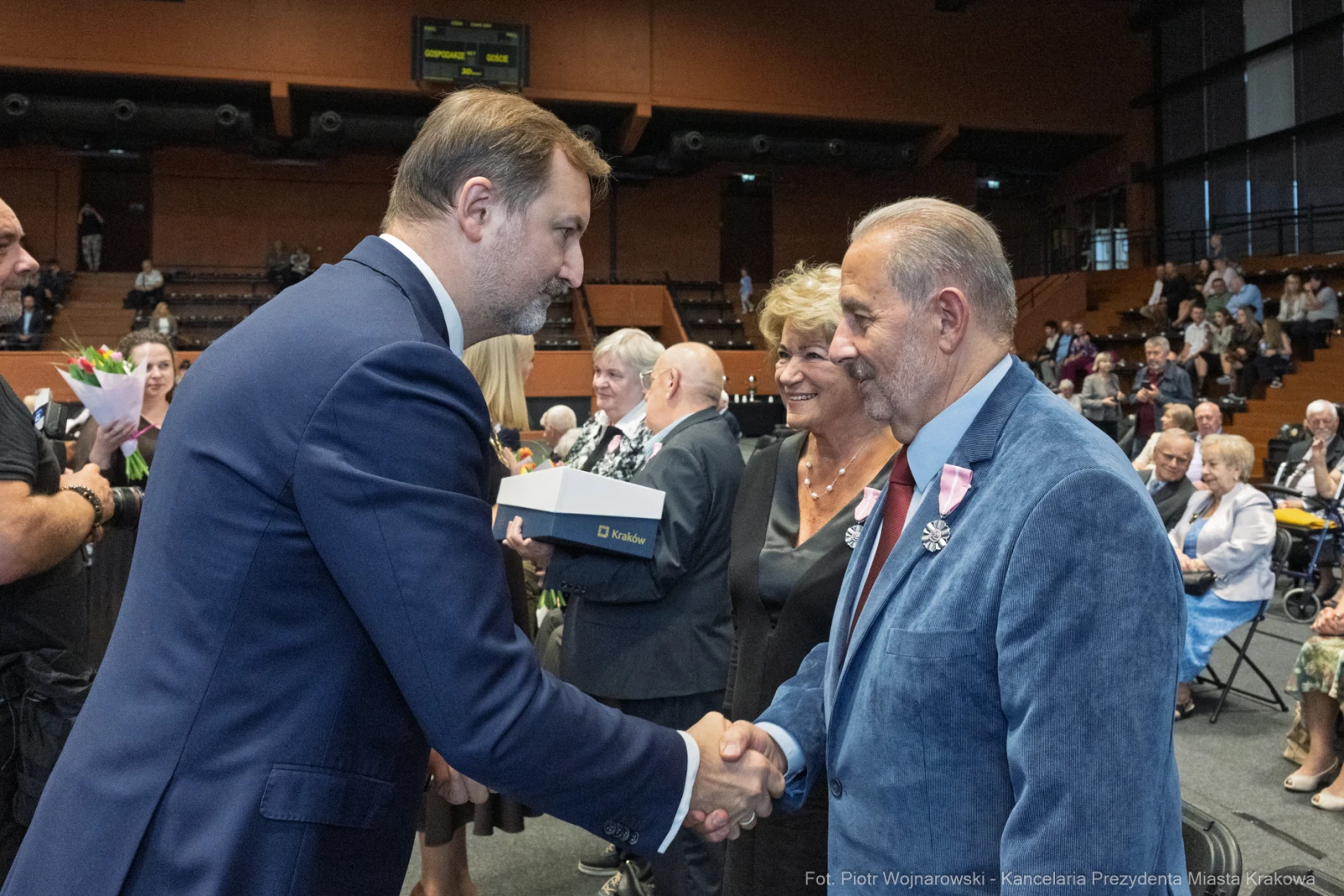 Uroczystość wręczenia nagród, mężczyzna w garniturze podaje rękę innemu mężczyźnie.  Autor: Piotr Wojnarowski