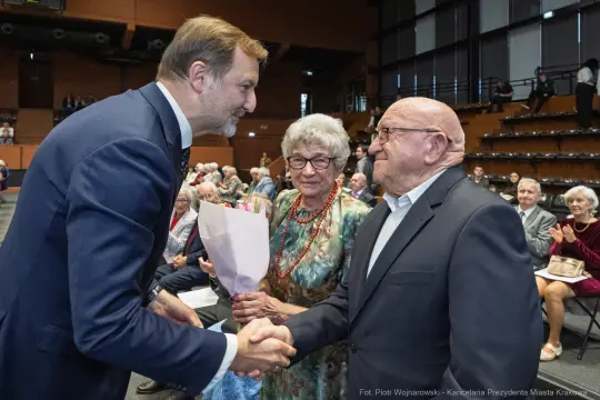 Uroczystość wręczenia kwiatów starszym parom w sali widowiskowej.