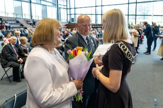 Uroczystość wręczenia nagród z kwiatami i gratulacjami.