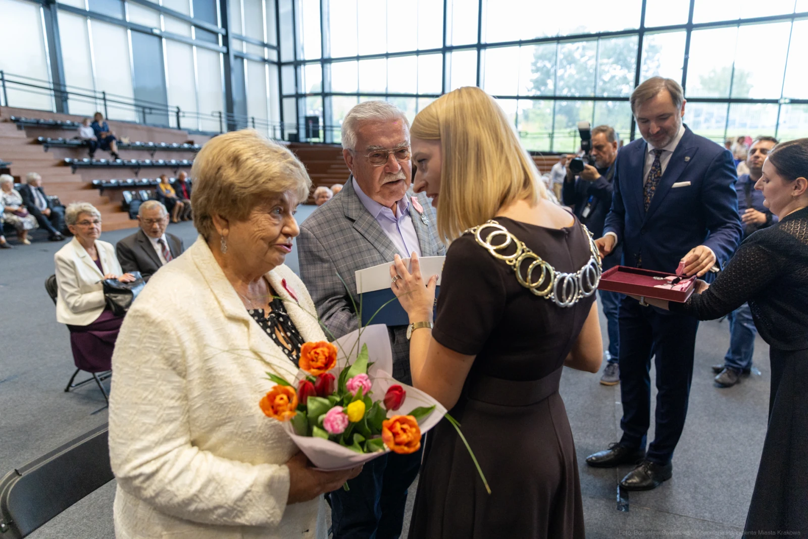 Uroczystość wręczenia nagród z kwiatami i medalami w tle.  Autor: Bogusław Świerzowski