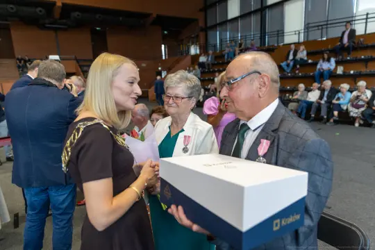 Wręczenie nagrody, rozmowa z laureatami, obecność gości w tle.