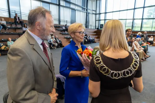 Uroczystość wręczenia kwiatów w sali z widownią.