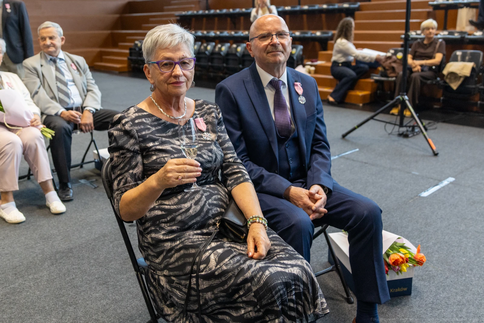 Uroczystość wręczenia odznaczeń, para siedząca na widowni z kieliszkami.  Autor: Bogusław Świerzowski