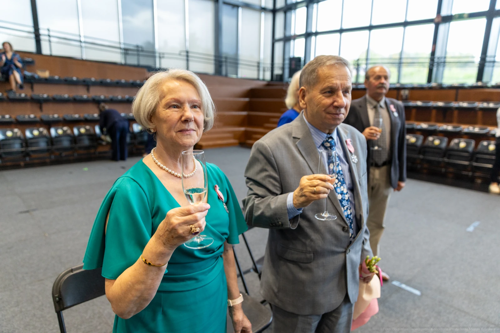 Para osób w eleganckich strojach trzyma kieliszki, celebrując wyjątkowy moment.  Autor: Bogusław Świerzowski