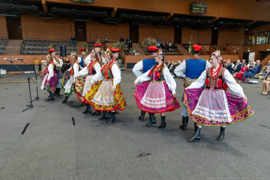 Grupa tancerzy w tradycyjnych polskich strojach ludowych podczas występu.