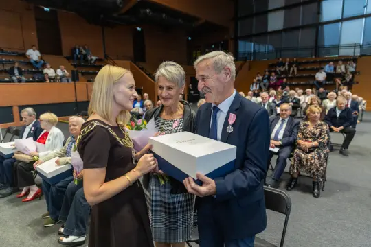Wręczenie nagrody przez kobietę mężczyźnie w obecności publiczności.