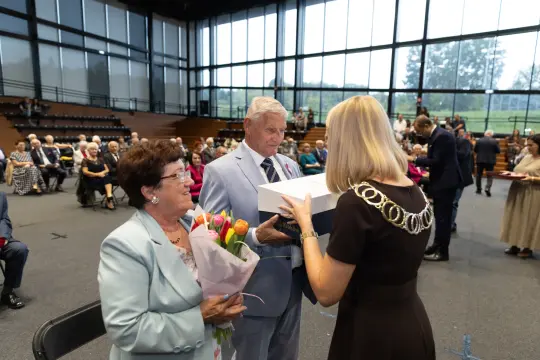 Uroczystość wręczenia nagród z kwiatami i prezentami dla jubilatów.