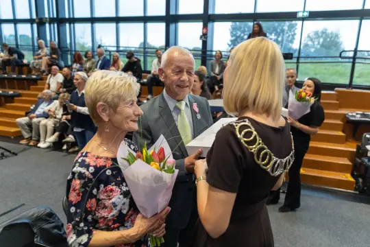 Uroczystość wręczenia nagród z kwiatami i uśmiechami uczestników.