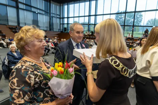 Uroczystość wręczenia nagród z kwiatami w rękach uczestników.