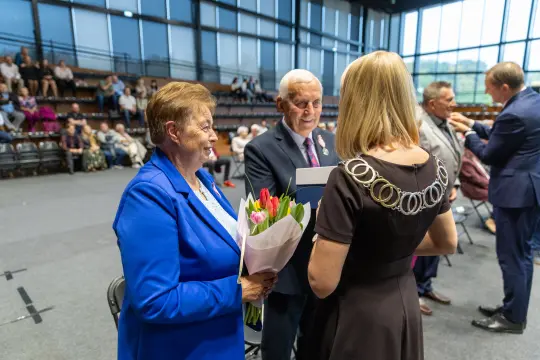 Uroczystość wręczenia nagród z kwiatami i medalami.