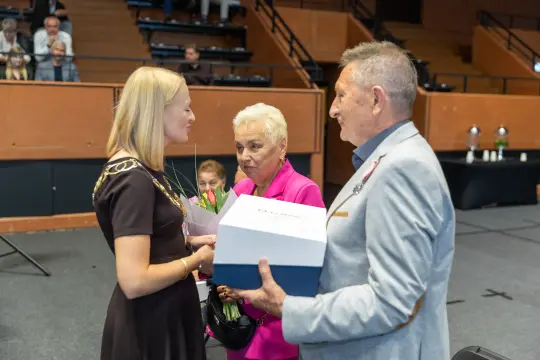 Wręczenie nagrody z kwiatami i prezentem w trakcie uroczystości.