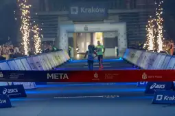 Biegacze przekraczają linię mety podczas wydarzenia sportowego w Krakowie.