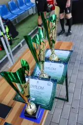 Puchary i dyplomy na stole, przygotowane na ceremonię wręczenia nagród.