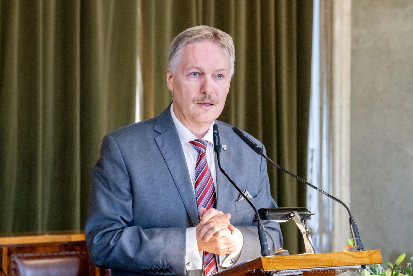 Mężczyzna w garniturze przemawia z mównicy.  Autor: Piotr Wojnarowski