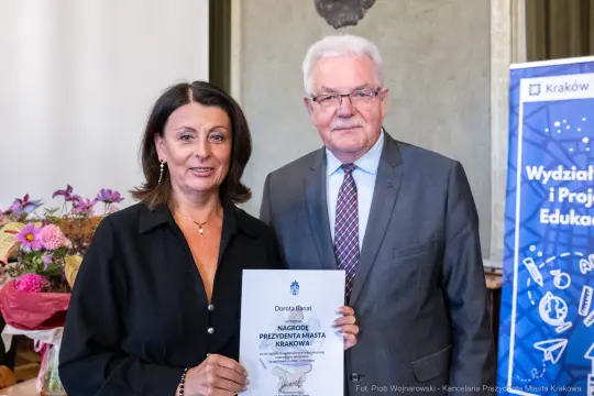 Kobieta i mężczyzna trzymają dyplom nagrody Prezydenta Miasta Krakowa.