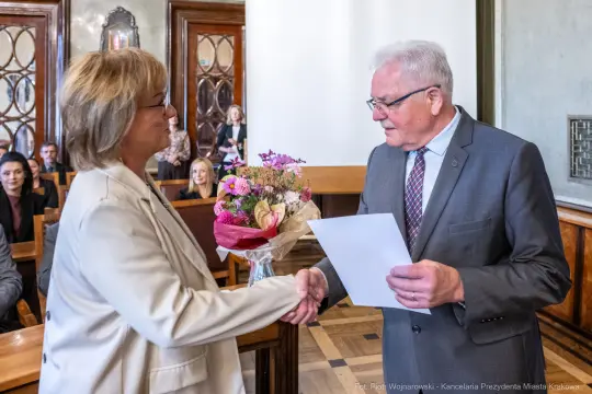 Uroczystość wręczenia kwiatów i gratulacji w sali miejskiej.